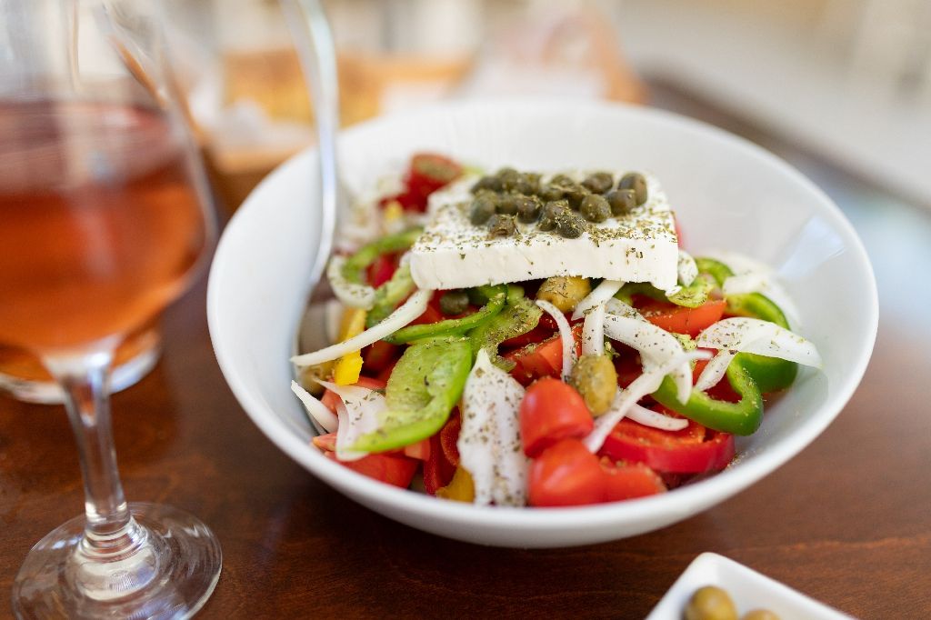 Traditional,Greek,Salad,And,Carafe,Of,Wine,In,A,Tavern