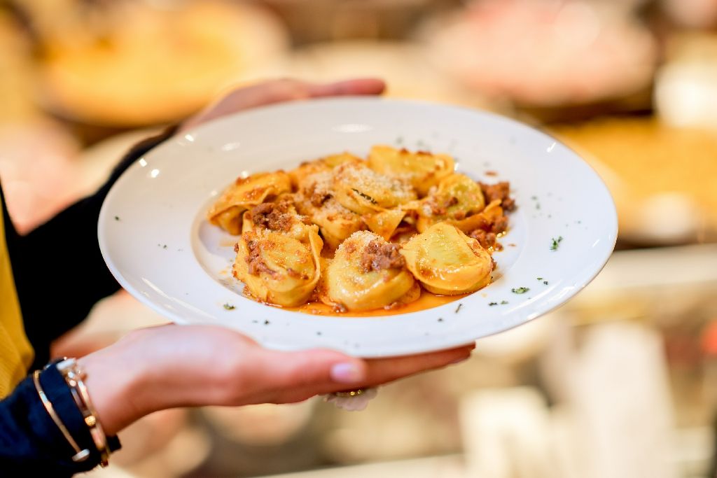 Holding,A,Plate,With,Traditional,Ring-shaped,Pasta,Tortellini,With,Bolognese