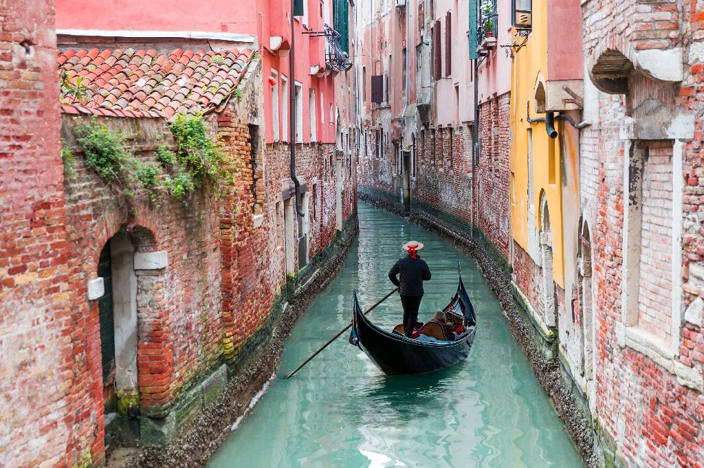 Venetian,Gondolier,Punting,Gondola,Through,Green,Canal,Waters,Of,Venice