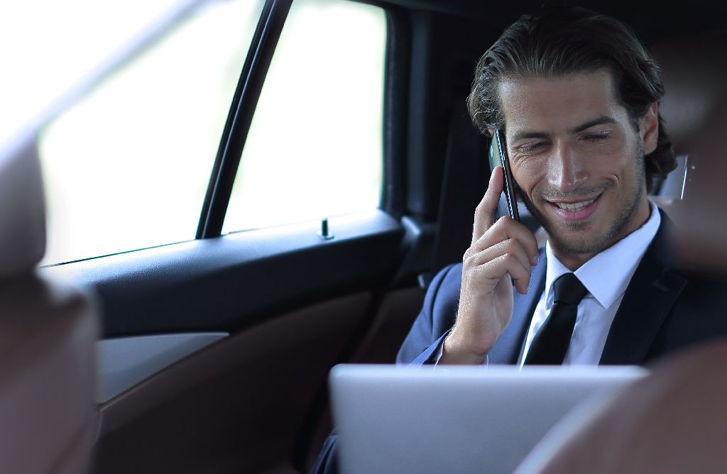 businessman in his car talking on the smartphone