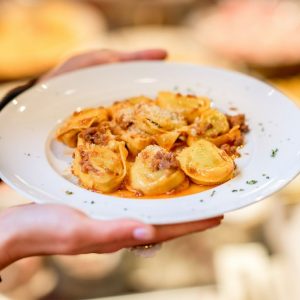 Holding,A,Plate,With,Traditional,Ring-shaped,Pasta,Tortellini,With,Bolognese